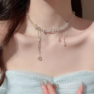 Detailed view of iridescent beaded necklace with cascading crystal tassels on model