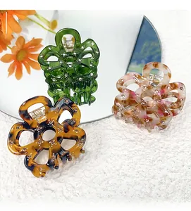 Detailed view of hollow five-petal flower hair claws with rhinestones and acetate textures