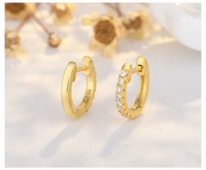 Macro view of S925 sterling silver gold earrings with stud details and diamond accents