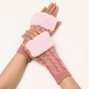 Detail of pink knitted fingerless gloves with soft faux fur cuffs and cable knit texture