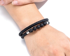 Detail of double-layer men's bracelet with black braided leather and lava stone beads