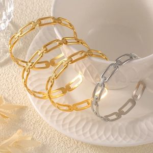 Bracelet jonc chaîne minimaliste en finition or et argent sur céramique blanche