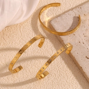 Detailed macro of three gold-plated stainless steel bangles with sea life and zircons