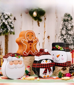 Detailed view of four Christmas gingerbread and snowman tin boxes on a festive wooden stand