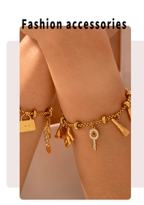 Detail of 18K gold plated titanium steel bracelet with diamond lock and key charms