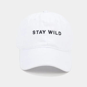 Close-up of Stay Wild black embroidery on a premium white cotton baseball cap