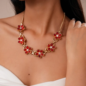 Detail of vintage red flower necklace with gold chain and sparkling rhinestones
