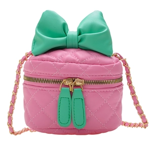 Pink quilted girls crossbody bag with a large green bow and golden chain strap