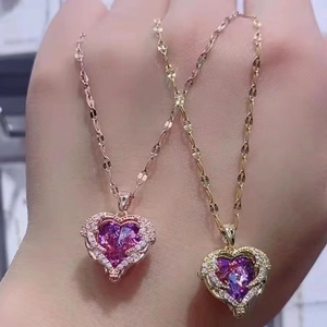 Detail of heart-shaped wing necklaces in gold and rose gold with purple gems