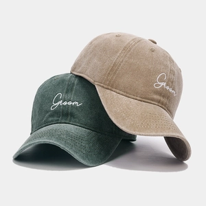 Detailed close-up of 'Groom' embroidery and washed twill fabric on vintage baseball caps