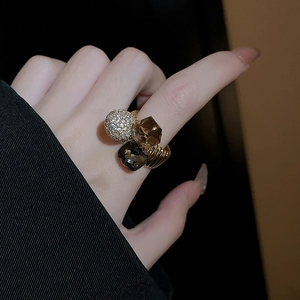 Close-up of gold-plated ring with crystal square stones and pave sphere on finger