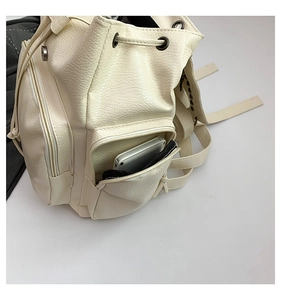 Close-up of cream backpack showing lychee texture, drawstring and functional side pocket