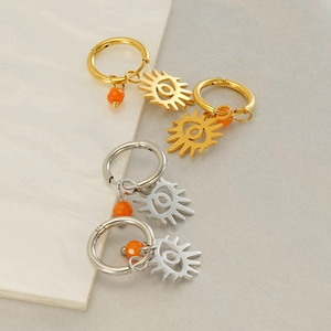 Golden and silver stainless steel evil eye hoop earrings with orange sun charm pendants