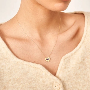 S925 sterling silver evil eye heart necklace with blue and white stones worn by a model