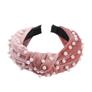 Detailed view of pink velvet headband featuring knotted design and white pearl beads