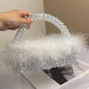 Macro detail of white ostrich feathers and iridescent beaded design on evening handbag