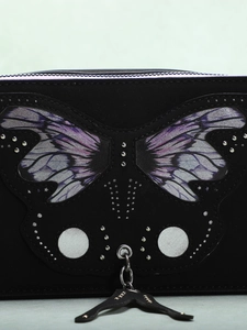 Detail of black leather camera bag with blue gradient butterfly patch and silver studs