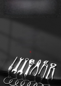 Detailed close-up of zinc alloy tool keychains with polished silver finish on leather