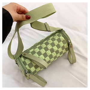 Detailed macro view of the green checkerboard cylindrical bag with textured ruched fabric