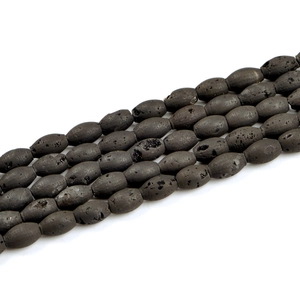 Macro shot of oval black lava rock beads with porous texture for DIY jewelry making