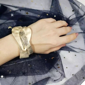 Fashionable gold wide cuff bracelet featuring cracked texture and matte heart clasp