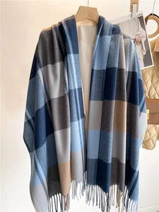 Dettaglio della trama a quadri blu tipo cashmere e delle frange terminali della sciarpa
