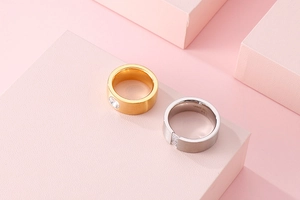 Macro shot of gold and silver titanium steel rings with square zirconia on pink display