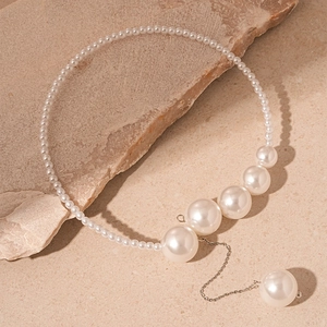 Vue détaillée du collier à pampilles en perles vintage avec chaîne argentée sur pierre