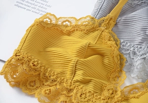 Close-up of yellow ribbed cotton bra featuring delicate floral lace trim and stripes