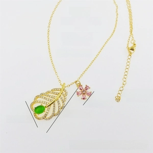 Dettaglio del ciondolo a foglia placcato oro 18K con pietra verde e fiore di zircone rosa