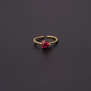 Detail of red heart-shaped gemstone ring with gold beaded adjustable band