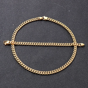 Detailed view of golden Cuban link chain necklace and bracelet set on black background