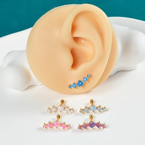 Detailed close-up of curved opal cartilage studs in 5 vibrant colors on gold plating