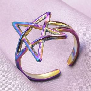 Macro view of adjustable rainbow stainless steel star ring on purple silk fabric