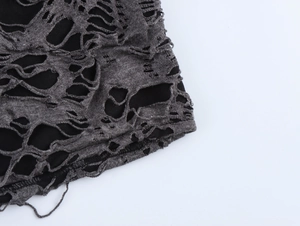 Détail macro du tricot gris avec design déchiré et doublure noire contrastée