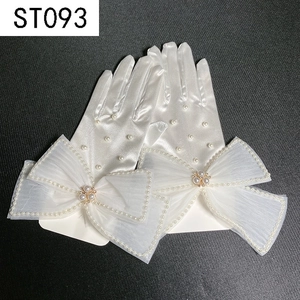 Detail of short white satin bridal gloves featuring decorative bows and pearl accents