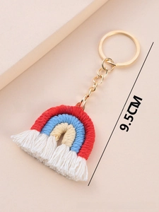 Detailed view of handmade woven rainbow keychain with cotton tassels and gold metal clip