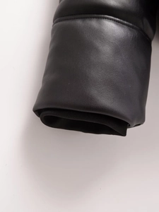 Détail des manches d'une veste en cuir noir avec poignets coupe-vent en maille