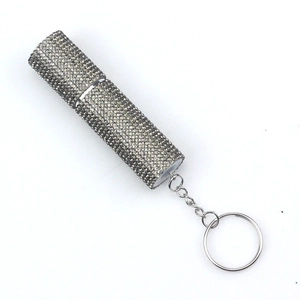 Macro detail of the sparkling rhinestones on the silver portable perfume bottle