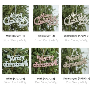 Glittery Merry Christmas letter ornaments in pink and champagne on a green tree