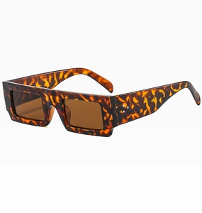 Detail view of tortoiseshell rectangle sunglasses with metal rivets and brown lenses