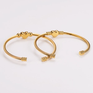 Set of two gold stainless steel open heart bangles with twisted rope design on white background