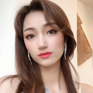 Close-up of model wearing silver tassel earrings with sparkling rhinestones for women