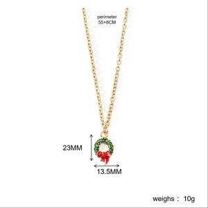 Christmas wreath pendant necklace with red bow detail on a golden chain link