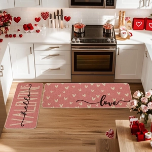 Detail of pink kitchen mat set with heart patterns and Hello Valentine text on wood floor
