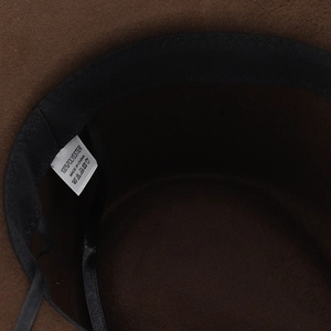 Detail view of the interior sweatband and care label inside a brown fedora hat