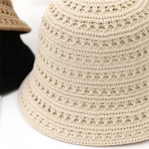 Primo piano della trama traforata in maglia sul cappello a secchiello beige da donna sole