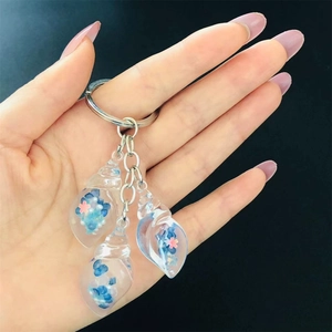 Close-up of translucent shell charms with floral filling on a silver keychain ring