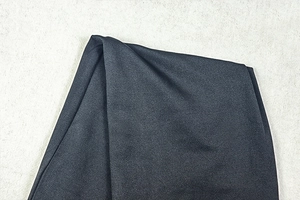 Gros plan sur la texture du tricot noir et le drapé d'une robe moulante dos nu
