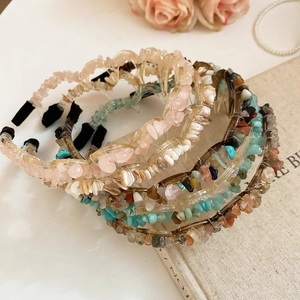 Close-up of stylish acrylic headbands with colorful irregular stone beads and resin texture